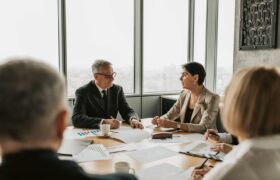 Business professionals engaged in a strategic meeting in a modern office setting with natural light.