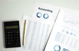 Calculator and accounting documents with charts on a workspace.