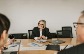 A professional business meeting with diverse professionals discussing reports in a modern office setting.