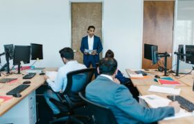 Business meeting with diverse team in modern office space, discussing projects.